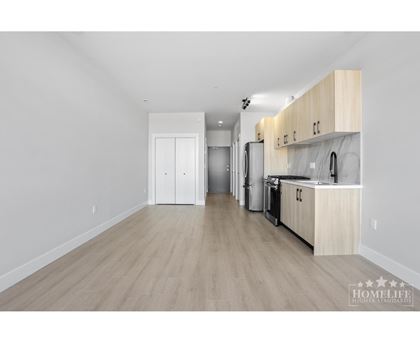 A kitchen with wooden floors and white walls.