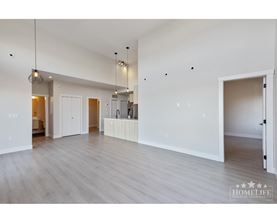 A spacious room with wooden floors and white walls.
