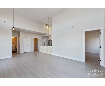 A spacious room with wooden floors and white walls.
