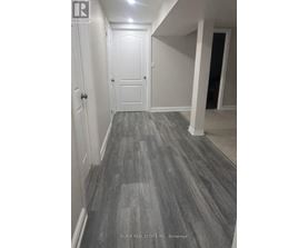 A hallway with a wooden floor and white walls.