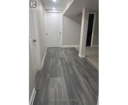 A hallway with a wooden floor and white walls.