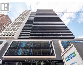 A tall building with a sign that says "Advent Realty Inc. Brokerage" in front of it.