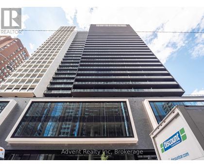 A tall building with a sign that says "Advent Realty Inc. Brokerage" in front of it.