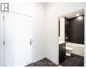 A white bathroom with a black tiled shower area.
