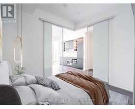A bedroom with a bed, a chair, and a plant.