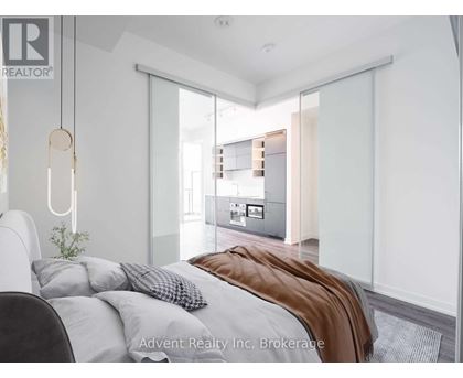 A bedroom with a bed, a chair, and a plant.