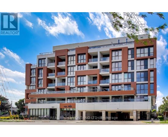 A large, modern apartment building with a clear blue sky above it.