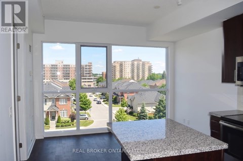 A view from a kitchen window looking out at a residential street.