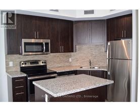 A kitchen with a granite countertop and stainless steel appliances.