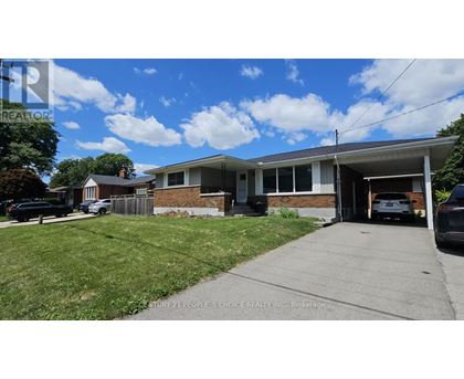 A house with a garage and a driveway in front of it.