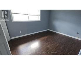 A room with wooden flooring and a window.