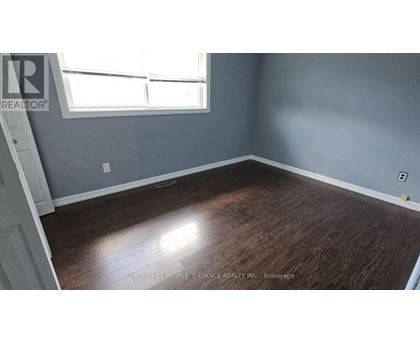 A room with wooden flooring and a window.