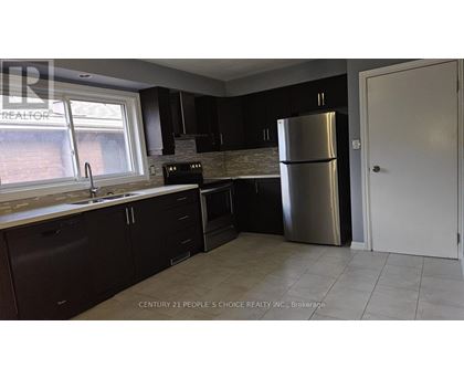 A kitchen with dark brown cabinets and a stainless steel refrigerator.