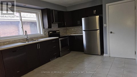 A kitchen with dark brown cabinets and a stainless steel refrigerator.