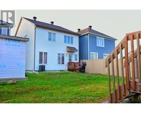 A house with a blue and white exterior is under construction with a sign that reads "Tyvek HomeWrap.".