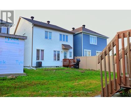 A house with a blue and white exterior is under construction with a sign that reads "Tyvek HomeWrap.".