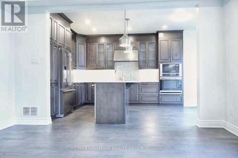 A modern kitchen with a center island and stainless steel appliances.