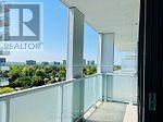 A balcony with glass railings and a view of the city.