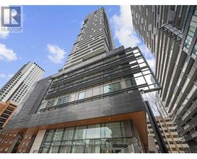 A tall building with a glass facade stands out against the sky.