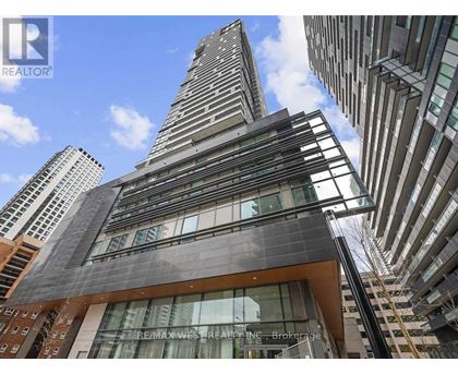 A tall building with a glass facade stands out against the sky.