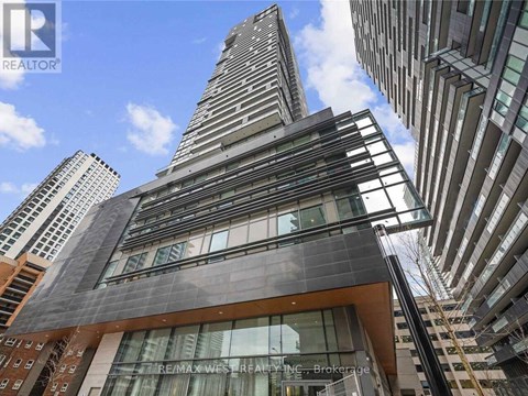 A tall building with a glass facade stands out against the sky.