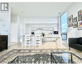 A modern kitchen with white cabinets and a black couch.