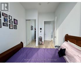 A bedroom with a purple bedspread and a bed on the left side.