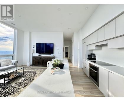 A modern living room with a large television and a view of the mountains.