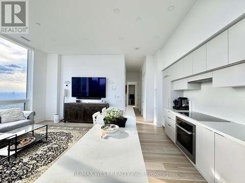 A modern living room with a large television and a view of the mountains.