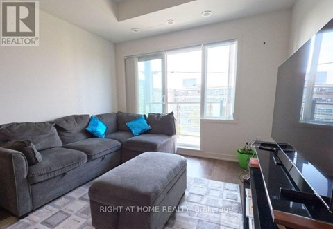 A living room with a grey couch and a small ottoman.