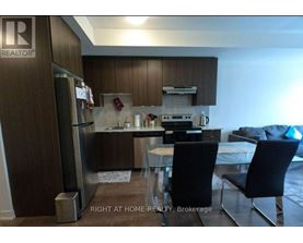 A kitchen with a refrigerator, sink, and stove.