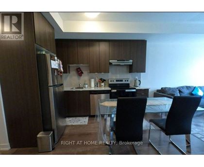 A kitchen with a refrigerator, sink, and stove.