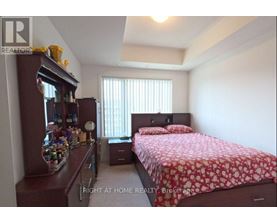 A bedroom with a bed, nightstand, and a cabinet with items on it.