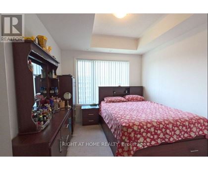A bedroom with a bed, nightstand, and a cabinet with items on it.