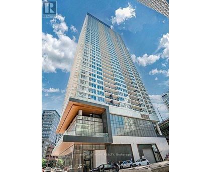 A tall building with a glass facade and a wooden top is surrounded by a clear sky.