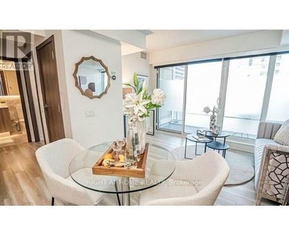 A modern living room with a glass table and a mirror on the wall.