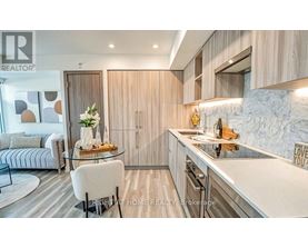 A modern kitchen with a glass table and a white chair.