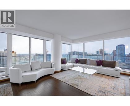 A living room with a white sofa and a glass coffee table.