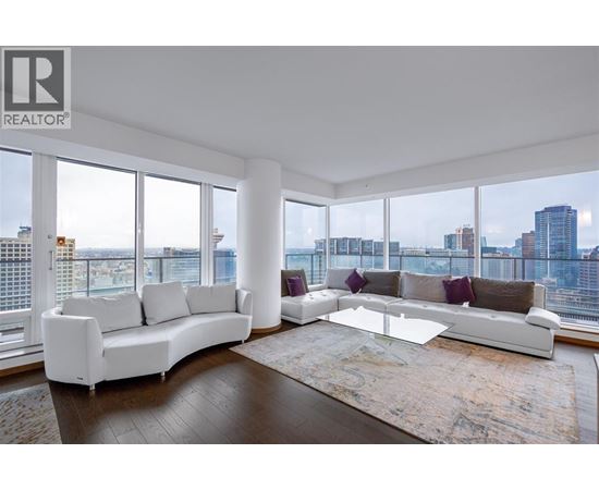 A living room with a white sofa and a glass coffee table.