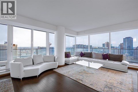 A living room with a white sofa and a glass coffee table.