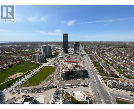 A cityscape with a clear sky and a road with multiple lanes.