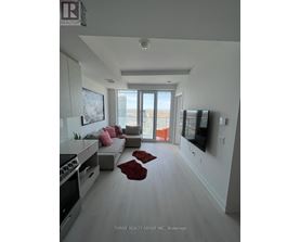 A modern living room with a large window and a flat screen TV mounted on the wall.