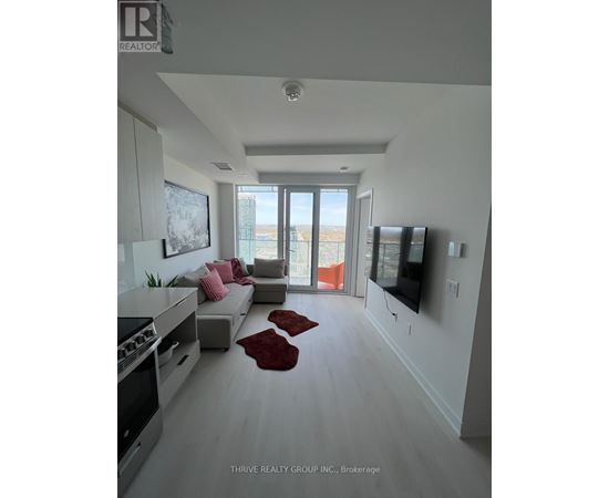 A modern living room with a large window and a flat screen TV mounted on the wall.