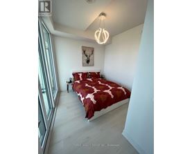 A bedroom with a bed, a nightstand, and a painting on the wall.
