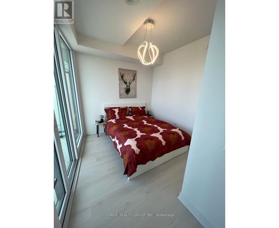 A bedroom with a bed, a nightstand, and a painting on the wall.