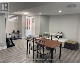 A dining room with a table and chairs.