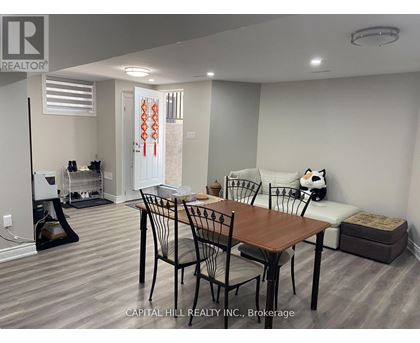 A dining room with a table and chairs.