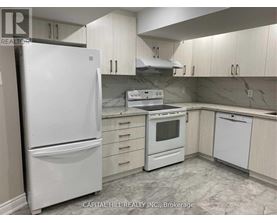 A white refrigerator stands in a kitchen with white cabinets and a marble floor.