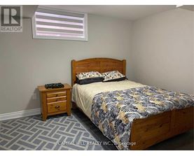 A bedroom with a bed, nightstand, and window.