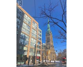A tall building with a green spire stands behind a modern building with a red sign that says "Castro".